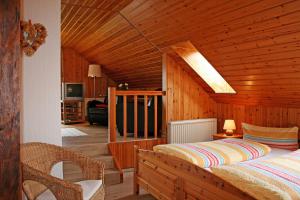 ein Schlafzimmer mit einem Bett in einem Holzzimmer in der Unterkunft Ferienhof Serck - Galeriewohnung in Fehmarn