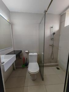 a bathroom with a shower and a toilet and a sink at Jee Foh Homestay in Miri +7 photos