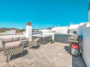 um pátio com um sofá e cadeiras num telhado em New Luxurious house with rooftop terrace and pool em Nerja