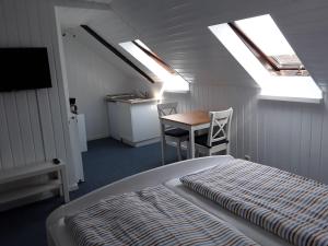 Schlafzimmer mit einem Bett, einem Tisch und Oberlichtern in der Unterkunft Doppelzimmer Serck in Fehmarn