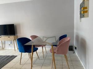 een eetkamer met een glazen tafel en blauwe stoelen bij Appartement T2 Kaweni in Mamoudzou