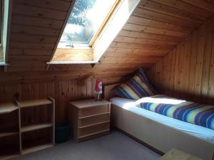 Bett in einer Holzhütte mit Fenster in der Unterkunft Ferienhof Serck - Große Wohnung in Fehmarn