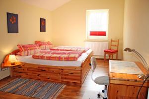 ein Schlafzimmer mit einem Bett und einem Stuhl und einem Fenster in der Unterkunft Ferienhof Serck - Backhaus 1 in Fehmarn
