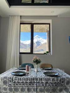 a table with a table cloth on it with a window at Hotel Axien Kazbegi in Kazbegi