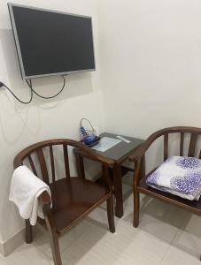 una mesa y sillas con TV en la pared en Phòng đơn có cửa sổ thoáng mát khép kín + Thang máy, en Hanói