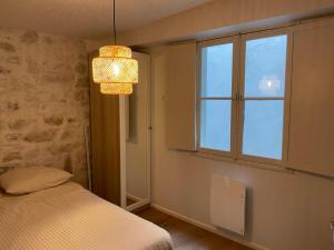 um quarto com uma cama, uma janela e um lustre em Appartement hyper centre 2 chambres em Baiona