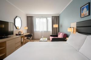a hotel room with a large bed and a desk at Hilton Garden Inn Budapest City Centre in Budapest