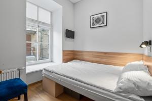 um pequeno quarto com uma cama e uma janela em Stay Express em Vilnius