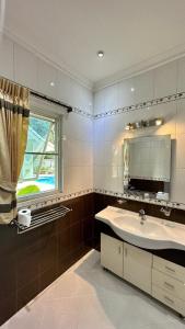 a bathroom with a sink and a mirror and a window at IvyRich Pool Villa Chiang Mai in Hang Dong