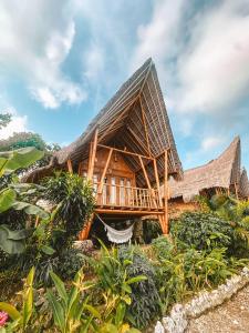 a bamboo house with a thatched roof at Penida Bambu Green in Nusa Penida