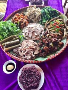 un plato de comida en una mesa púrpura en Nhà nghỉ 28 - Homestay Biên Thùy, Bản Lác, Mai Châu, Hòa Bình en Mai Chau