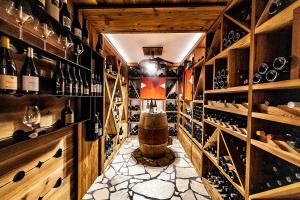 a wine cellar with a barrel and a bottle of wine at Rifugio Crëp de Munt in Corvara in Badia