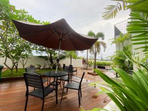 una mesa negra y sillas con sombrilla en ONYX HOTEL & VILLA, en Tanjunguban