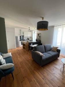 Una sala de estar con un sofá y una cocina. en Le Coeur de Rodez, en Rodez