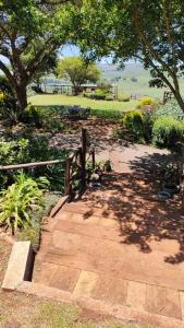 a brick path leading to a park with a tree at Serenity Alpaca Guest Farm in Lions River