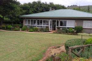 a house with a large yard in front of it at Serenity Alpaca Self Catering Cottage in Lions River