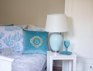 a lamp on a table next to a bed with a pillow at Casa de Buenas in Sarbinowo +32 photos