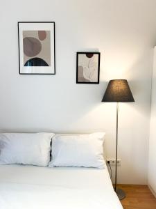 a bedroom with a white bed and two framed pictures at MyRoom Apartment in Munich in Munich