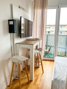 um quarto com uma secretária, um computador e uma janela em MyRoom Apartment in Munich em Munique