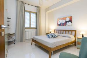 a bedroom with a bed and two chairs in it at Villa Bizzarria in Castellammare del Golfo