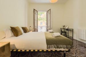 a bedroom with a large white bed and a window at Sagrada Familia 360 in Barcelona
