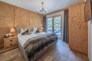 sypialnia z dużym łóżkiem i żyrandolem w obiekcie Gletscherblick- serviced apartments w mieście Obergurgl