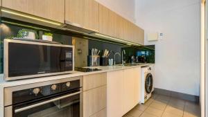 a kitchen with a microwave and a dishwasher at Mullum Haven 3 - Central & Stylish Townhouse in Mullumbimby +12 photos