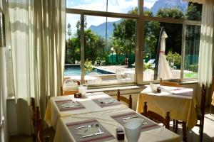 a dining room with two tables and a large window at Hotel Diana in Riva del Garda