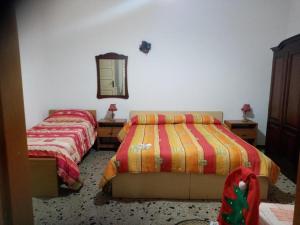 sypialnia z 2 łóżkami i lustrem na ścianie w obiekcie Antichi Sapori da Speranza w mieście Gavoi