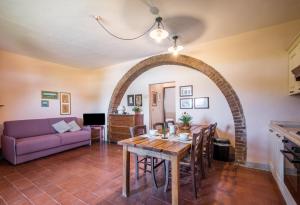 ein Wohnzimmer mit einem Tisch und einem lila Sofa in der Unterkunft Podere del Pereto Bio- 203 in Rapolano Terme