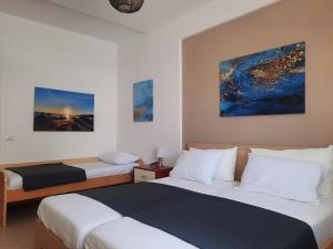 a bedroom with two beds and a painting on the wall at Himara Sea Sunny Home in Himare