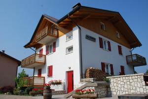 a white building with a wooden roof at Affittacamere Dai Stoneri in Cavareno