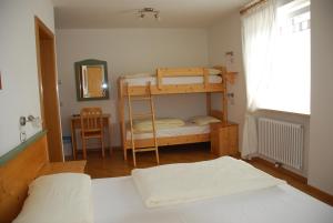 a bedroom with two bunk beds and a desk at Affittacamere Dai Stoneri in Cavareno