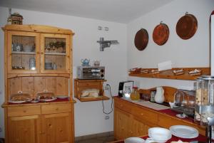 a kitchen with wooden cabinets and a counter top at Affittacamere Dai Stoneri in Cavareno +16 photos