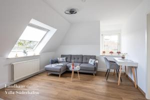 a living room with a couch and a table at Landhaus Villa Süderhafen - Family & Friends in Nordstrand