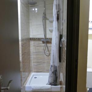 La salle de bains est pourvue d'une baignoire et d'une douche avec rideau de douche. dans l'établissement Le Bosquet, à Aiguines