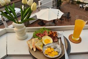 琅勃拉邦的住宿－Monsane villa，桌上的一盘早餐食品,加上一杯橙汁