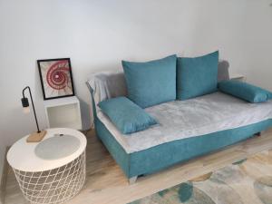 a couch with blue pillows in a living room at Harmony House in Oradea