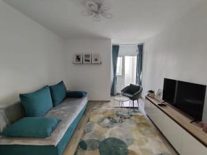 a living room with a couch and a flat screen tv at Harmony House in Oradea