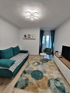 ein Wohnzimmer mit einem Sofa und einem TV in der Unterkunft Harmony House in Oradea