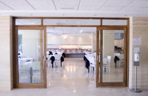 uma sala de jantar com mesas e cadeiras e portas de vidro em Paraiso Beach by Hoteles Centric -Adult Only em Es Cana