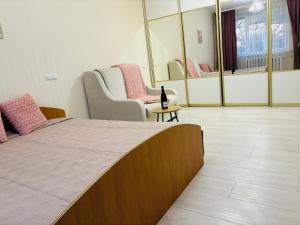a room with a bed and chairs and mirrors at Paola Apartment in Chişinău