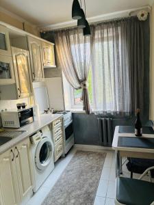 a kitchen with a washing machine and a window at Paola Apartment in Chişinău