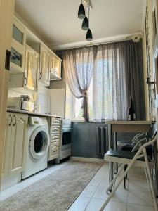 a kitchen with a washing machine and a window at Paola Apartment in Chişinău