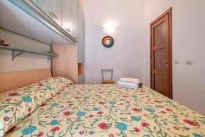 a bedroom with a bed with a floral bedspread at Attico vista mare Borgo La Palma 16 in Badesi