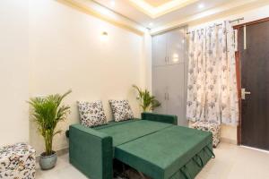 a room with a green bed and two chairs at Homlee-Vasundhara 5BHK with Terrace(For Function) in Ghaziabad