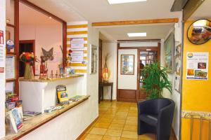 a waiting area of a pharmacy with a black chair at Hôtel La Croix de Malte in La Ciotat