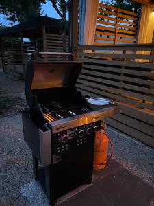 a barbecue grill sitting outside of a house at Mobile Home - Sea La Vie in Biograd na Moru