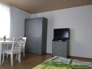 Schlafzimmer mit einem Bett, einem TV und einem Tisch in der Unterkunft Gästezimmer M. Schubert in Oberelbert