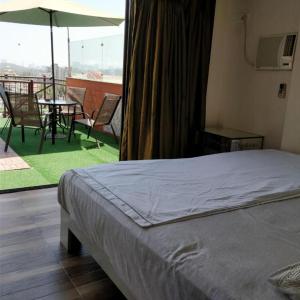 a bedroom with a bed and a balcony with a table at Spruce Peak Villa in Mumbai
